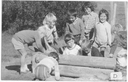 Boys playing in sand pit (on school boundary ?)