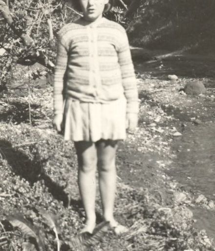 Young Girl standing beside stream