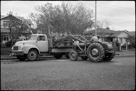 Digger loading tree stump onto truck